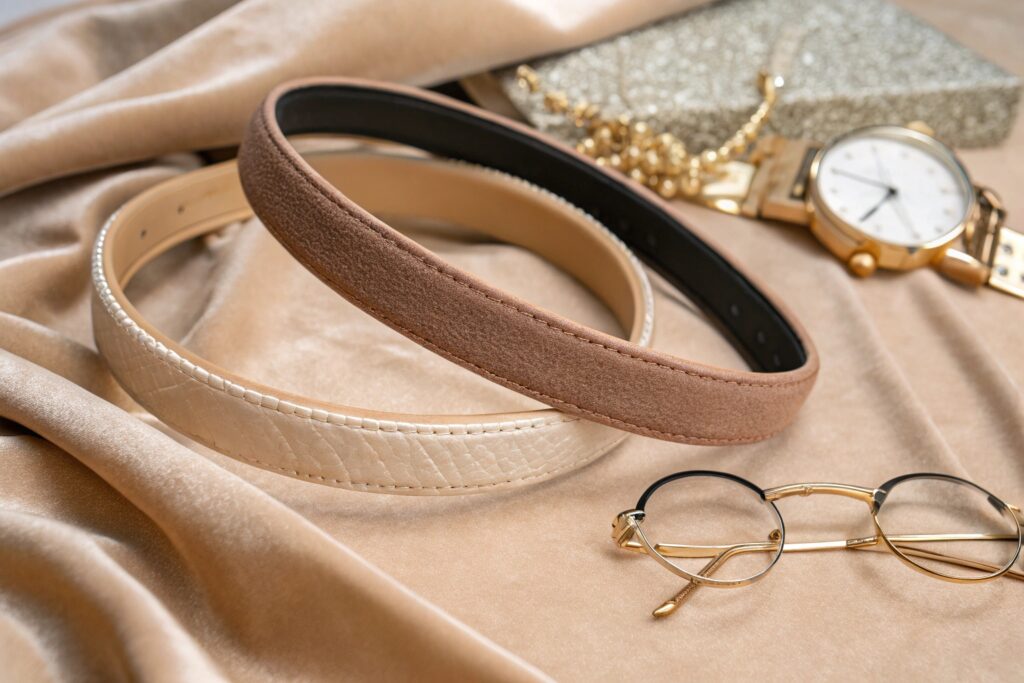 Two stylish leather belts on velvet with gold accessories